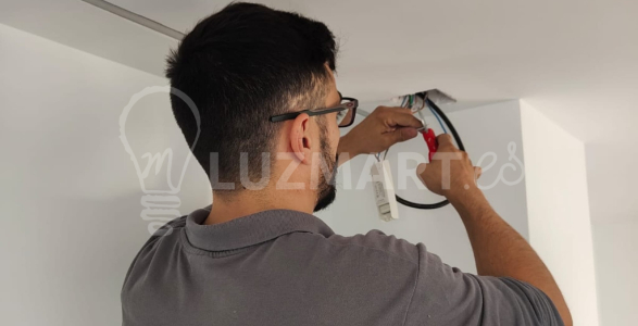 la imagen muestra un electricsta trabajando y sacando un punto de luz