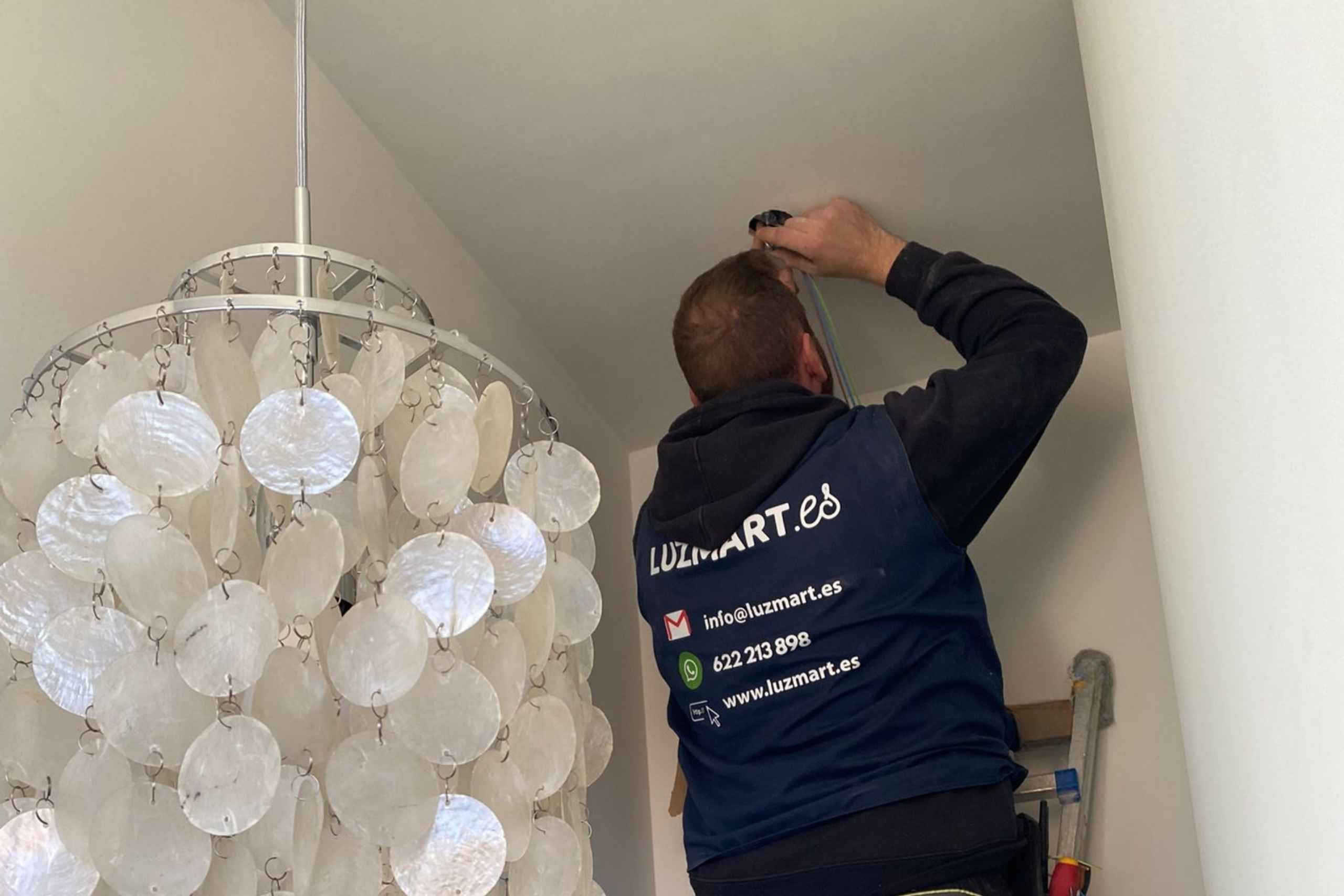 en la imagen se ve a un electricista realizando una operación de instalación o mantenimiento preventivo en la instalación eléctrica